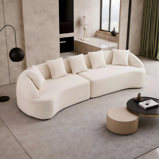 Modern living room with a white sofa and round ottoman.